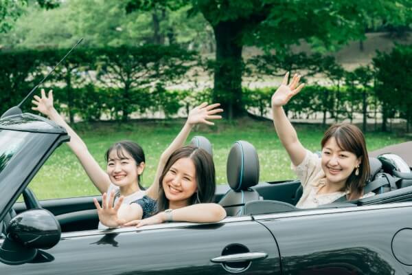 オープンカーに乗る女性たち