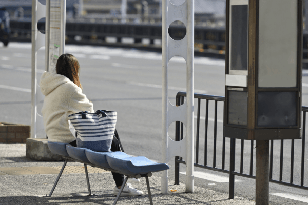 バス停で待つ女性